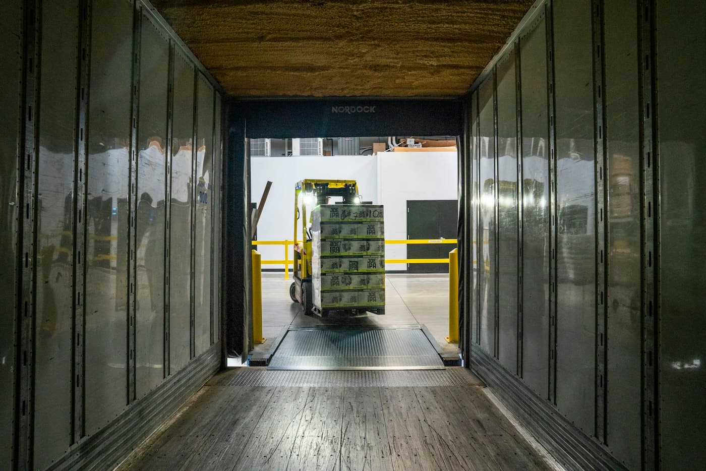Forklift bringing pallets to an open trailer at the receiving dock