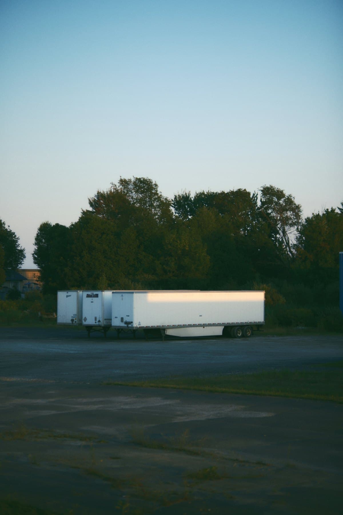 Loaded trailers parked alone in an empty lot at dusk
