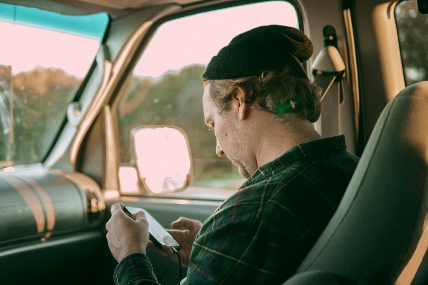 Driver in the cab checking the driver app on his phone