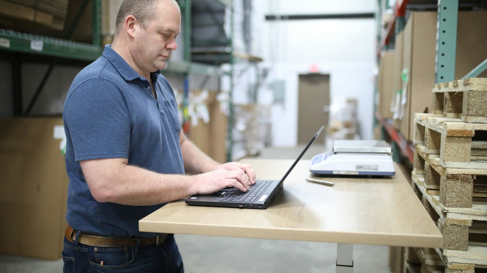 Logistics manager at a laptop in a warehouse