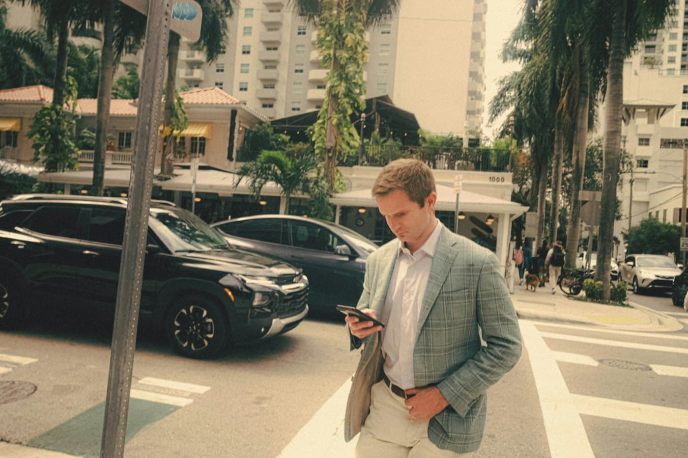 Shipper in a blazer reading his phone on the way to the car at the end of the day