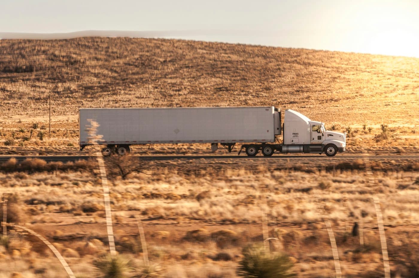 Tractor-trailer on an interstate in late afternoon light